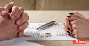 Two sets of clasped hands facing off over a paper document and two wedding rings. SB Lawyers can help with your separation with specialist family law solicitors Two sets of clasped hands facing off over a paper document and two wedding rings. SB Lawyers can help with your separation with specialist family law solicitors
